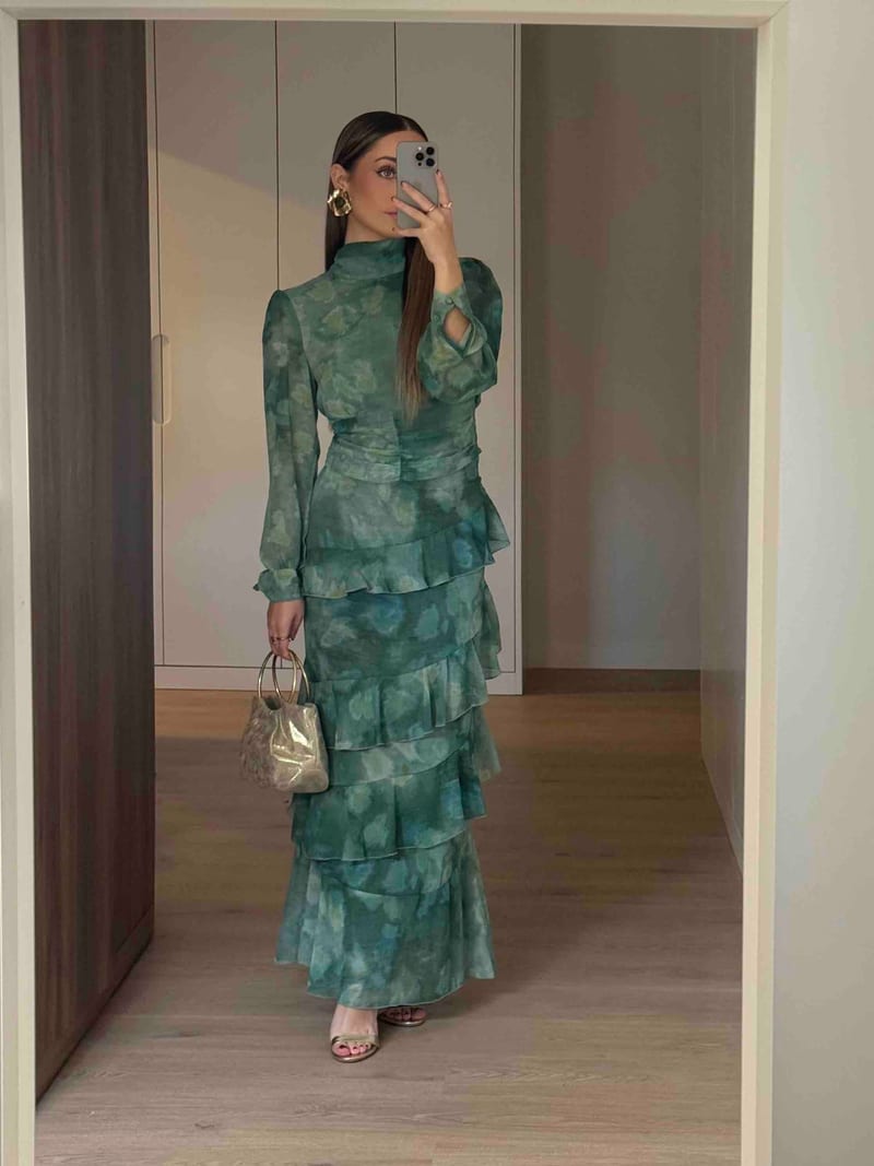 Conjunto Emerald de Baymo con blusa de manga larga, falda verde de volantes y bolso dorado