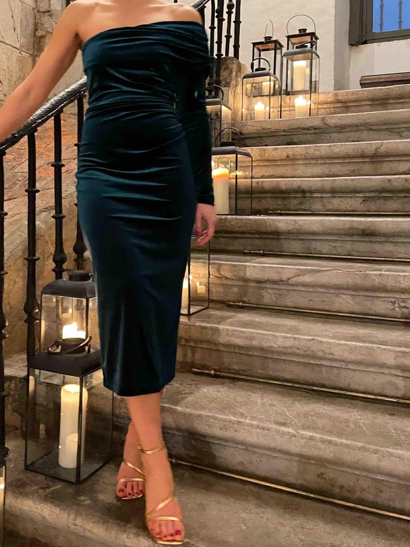 Vestido midi de terciopelo verde petróleo de The Are, ajustado y de una sola manga, con sandalias doradas de tiras en una boda de noche en diciembre